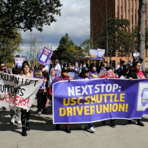 Photo of USC students and shuttle drivers marching through USC campus