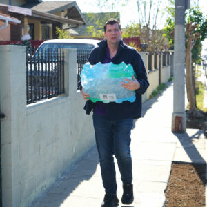 President David Green carrying a case of bottled water.